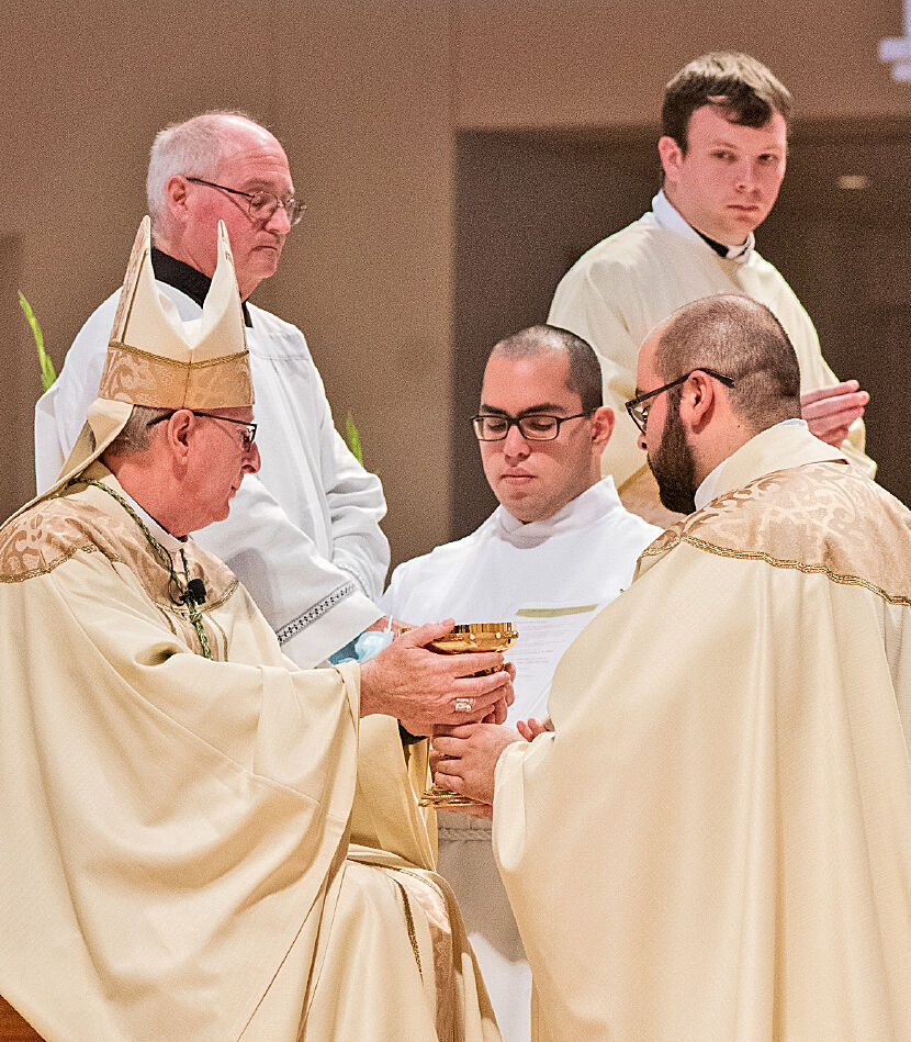 Bishop Noonan gives Father Francisco Ojeda the chalice as he hands over the bread and wine. (MARJORIE DURANTE)